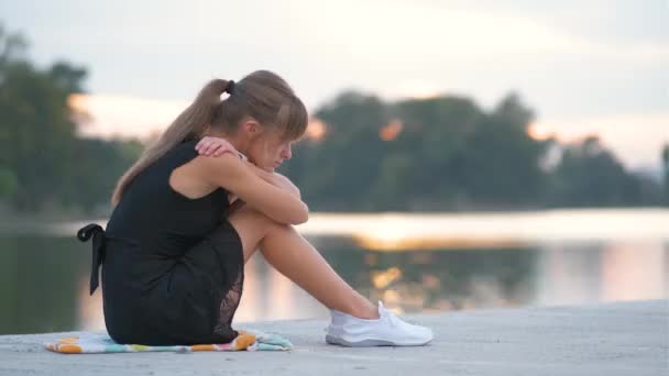 En deprimerad ung kvinna som sitter ensam utomhus och gråter sorgset. Begreppet depression och känslor — Stockvideo