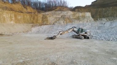 Taş ocağındaki çakıl kaynaklarını kazmak için kazıcı ekipmanlarıyla birlikte inşaat kum taşı malzemelerinden oluşan açık maden sahası