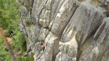 Güçlü erkek tırmanıcı kayalık dağın dik duvarına tırmanıyor. Sporcu zor yolu aştı. Ekstrem spor hobisi konsepti