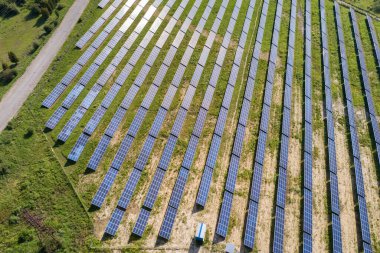 Yeşil alandaki güneş enerjisi santralinin havadan görüntüsü. Temiz ekolojik enerji üretmek için panelleri olan elektrik çiftliği