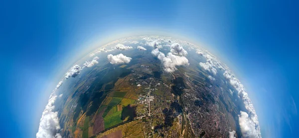 Luftaufnahme aus großer Höhe von einem kleinen Planeten mit einer entfernten Stadt, die vor dem Regensturm von aufgeschwollenen Kumuluswolken bedeckt ist. Flugzeugbild der Landschaft bei bewölktem Wetter — Stockfoto