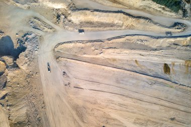 Kazı araçları ve çöp kamyonları ile inşaat endüstrisi için kireçtaşı malzemelerinin açık çukur madenciliğinin hava görüntüsü