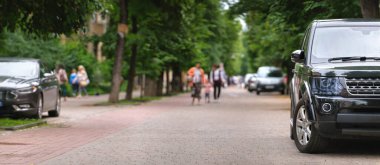 Şehrin caddesine park etmiş bir arabanın yakınına.