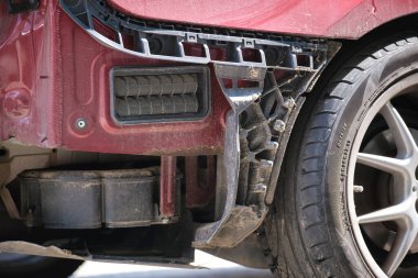 Çamurluğu hasarlı, kaza yapmış bir araba şehrin caddesine park edilmiş. Yol güvenliği ve araç sigortası kavramı