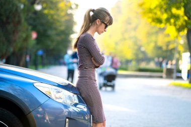 Genç bayan sürücü arabasının yanında dinleniyor sıcak yaz gününün tadını çıkarıyor. Seyahat ve kaçış konsepti