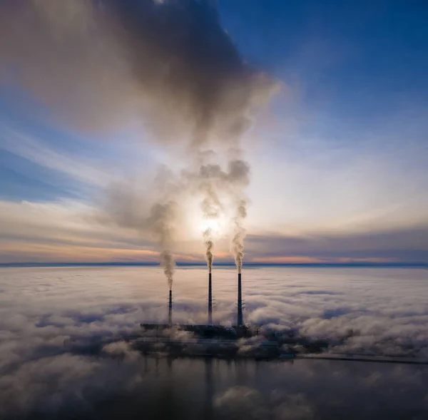 Uitzicht vanuit de lucht op hoge pijpen van kolencentrales met zwarte rook die bij zonsondergang de vervuilende atmosfeer opgaat — Stockfoto