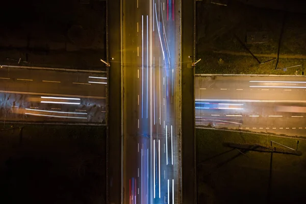 Luftaufnahme einer Straßenkreuzung mit starkem Verkehr in der Nacht. Blick von oben auf den städtischen Verkehr. Rush Hour mit Bewegungsunschärfe von Autofahrerampeln — Stockfoto