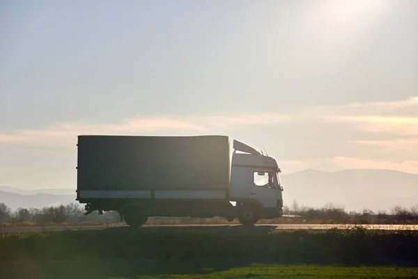 Vrachtwagen rijdt 's avonds op de snelweg en vervoert goederen. Levering transport en logistiek concept — Stockfoto