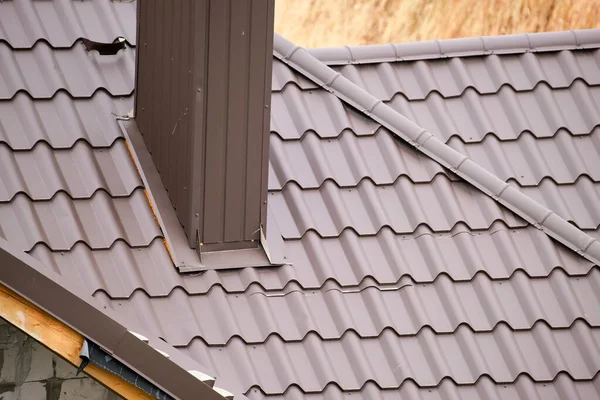 Skorsten på husets tak täckt med metalliska bältros under konstruktion. Kallad täckning av byggnaden. Fastighetsutveckling — Stockfoto