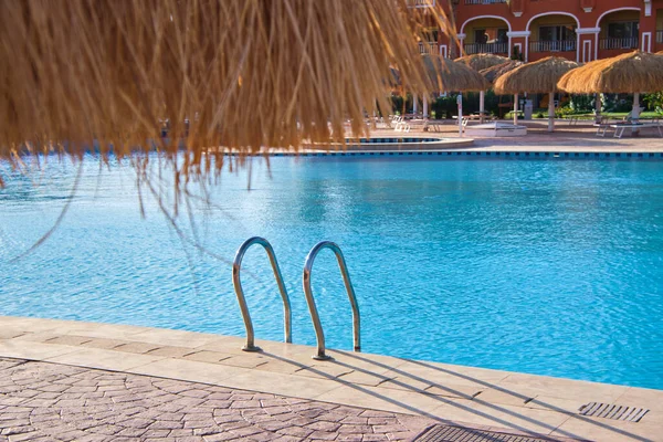 Primer plano de la barandilla de acero inoxidable de la piscina que desciende en el agua clara de la piscina de tortuga. Accesibilidad del concepto de actividades recreativas —  Fotos de Stock