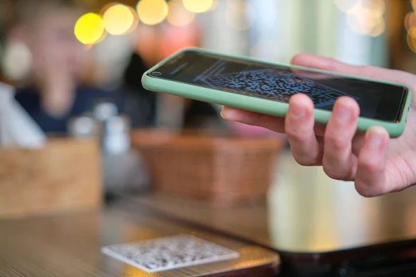 Закрытие гостевой руки при заказе еды в ресторане при сканировании qr-кода с помощью мобильного телефона для онлайн-меню — стоковое фото