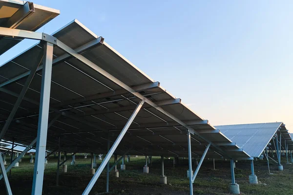 깨끗 한 생태학적 전기 에너지를 생산하기 위한 태양 전지 패널 이 줄줄이 늘어서 있는, 지속 가능 한 거대 한 발전소의 지상 철제 뼈대 — 스톡 사진