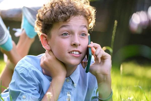 Feliz joven adolescente hablando por teléfono móvil al aire libre en el parque de verano. concepto de amistad en línea — Foto de Stock
