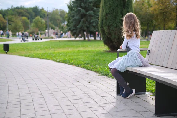 Porträt eines hübschen Mädchens auf einer Parkbank im Freien — Stockfoto