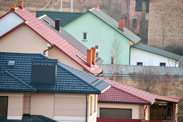 Case residenziali con tetti ricoperti di tegole metalliche e ceramiche in zona suburbana rurale — Foto Stock