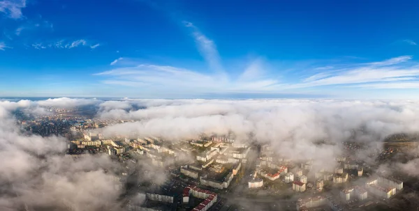 Vue aérienne supérieure des nuages blancs moelleux au-dessus de la ville moderne avec des bâtiments de grande hauteur — Photo