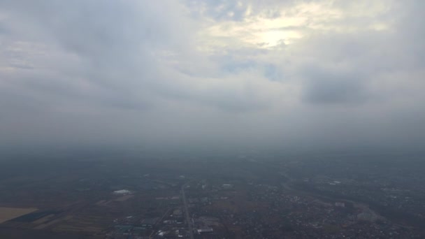 Αεροφωτογραφία από μεγάλο υψόμετρο της μακρινής πόλης καλυμμένη με φουσκωτά σύννεφα που σχηματίζονται πριν από την καταιγίδα. Αεροπλάνο άποψη συννεφιασμένο τοπίο — Αρχείο Βίντεο