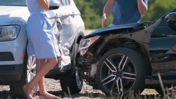 Rozzlobená žena a muž řidiči těžce poškozených vozidel volá pojišťovny o pomoc při autonehodě na straně ulice. Koncept bezpečnosti silničního provozu — Stock video