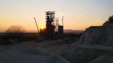 Çimento fabrikası inşaat için kum taşı malzemelerinin açık madenciliğinde. Gün batımında taş ocağında çakıl ocağı kazmak.