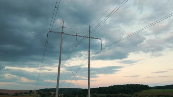 Donker silhouet van hoogspanningstoren met elektrische leidingen bij zonsondergang. Overdracht van elektriciteit — Stockvideo