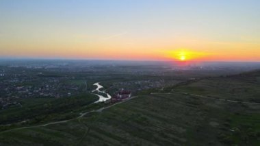 Yeşil ekili tarlaların, büyüyen ekinlerin ve parlak yaz akşamlarında uzak köy evlerinin hava manzarası.