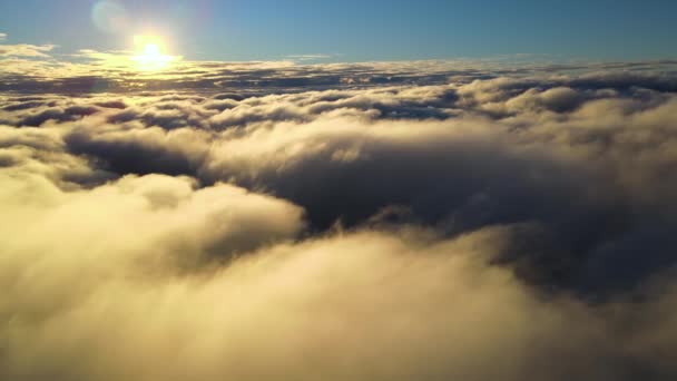 Воздушный вид сверху на большой высоте плотных кучевых облаков, летящих в вечернее время. Удивительный закат из окна самолета — стоковое видео