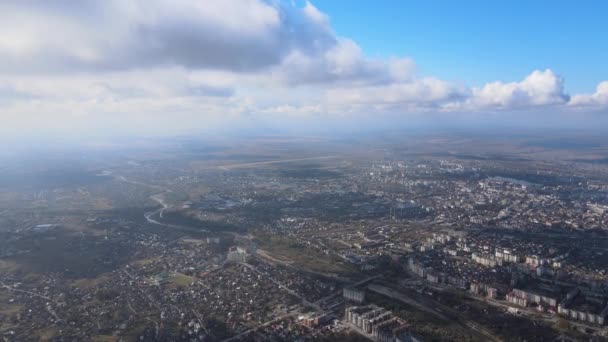 Légi kilátás a repülőgép ablakából nagy magasságban a távoli város borított fehér gömbölyű felhők — Stock videók