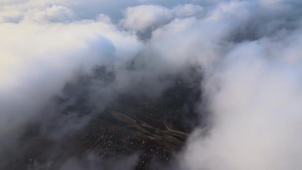 폭풍우가 오기 전에 형성되는 솜털 뭉치 구름으로 뒤덮인 멀리 떨어진 도시 의고 도에서 공중에서 바라본 모습. 비행기 의경치는 구름낀 지형이었다 — 비디오