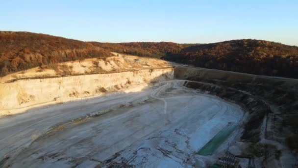 Vista aérea do local de mineração a céu aberto de materiais de pedra calcária para a indústria da construção com escavadeiras e caminhões basculantes — Vídeo de Stock