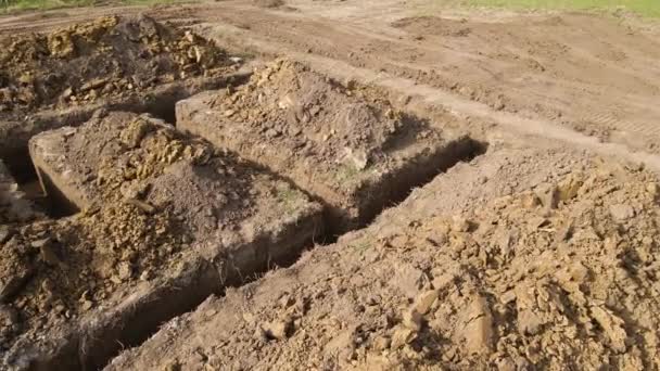 Uitgraven loopgraaf voor de bouw van nieuwe huis betonnen fundering op bouwplaats — Stockvideo