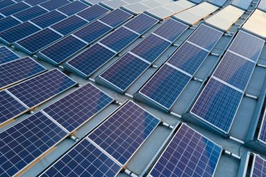 Temiz ekolojik elektrik enerjisi üretmek için sıralanmış mavi güneş fotovoltaik panelleri olan hava manzaralı çatı. Sıfır emisyon kavramı ile yenilenebilir elektrik