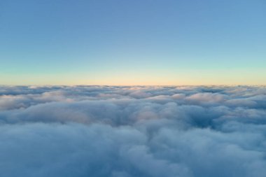 Yükseklerdeki uçak penceresinden akşam uçuşan yoğun kabarık kümülüs bulutlarının hava görüntüsü