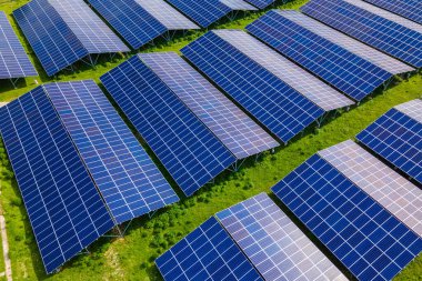 Temiz ekolojik elektrik enerjisi üretmek için sıra sıra güneş fotovoltaik panelleri olan sürdürülebilir büyük elektrik santralinin havadan görünüşü. Sıfır emisyon kavramı ile yenilenebilir elektrik