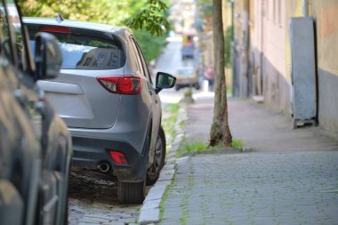 Sokak kenarında park halindeki arabalarla şehir trafiği