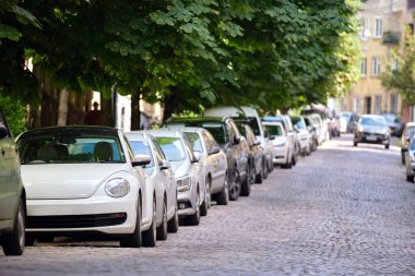 Sokak kenarında park halindeki arabalarla şehir trafiği