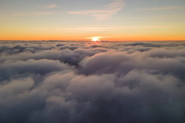 Αεροφωτογραφία από ψηλά σε μεγάλο υψόμετρο πυκνών φουσκωτών νεφών που πετούν το βράδυ. Καταπληκτικό ηλιοβασίλεμα από το παράθυρο του αεροπλάνου — Φωτογραφία Αρχείου
