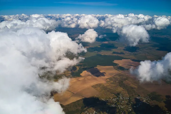 Aerial view from high altitude of earth covered with white puffy cumulus clouds on sunny day — Stock Photo, Image