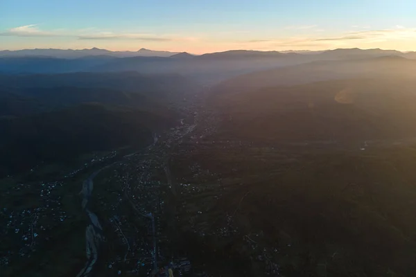 Légi felvétel nagy magasságból lakóházak hegyi faluban naplementekor — Stock Fotó