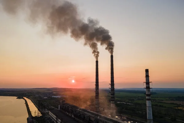 Luchtfoto van hoge pijpen van kolencentrales met zwarte rook die bij zonsondergang naar boven beweegt en vervuilende atmosfeer. Productie van elektrische energie met fossiele brandstoffen — Stockfoto