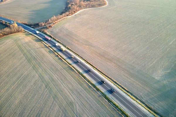 Vista aérea de la carretera interurbana con coches de conducción rápida al atardecer. Vista superior desde el dron del tráfico por carretera en la noche — Foto de Stock