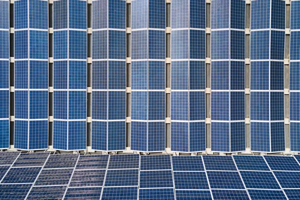 Vista aérea de la planta de energía solar con paneles fotovoltaicos azules montados en el techo del edificio industrial para producir electricidad ecológica verde. Producción del concepto de energía sostenible —  Fotos de Stock