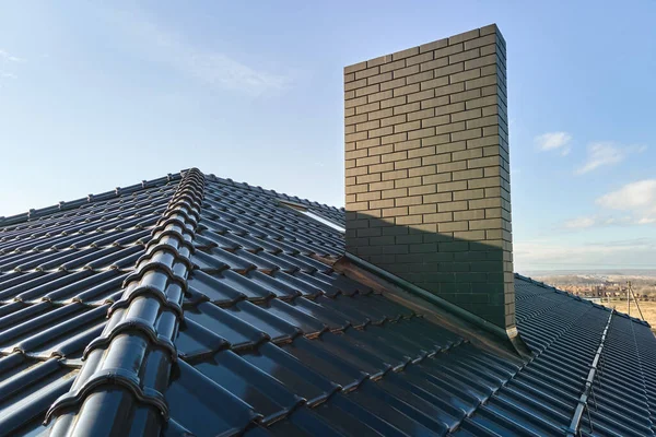 세라믹 대상포진으로 뒤덮인 지붕 위에 벽돌 굴뚝을 덮는다. 건축하는 일을 맡다 — 스톡 사진