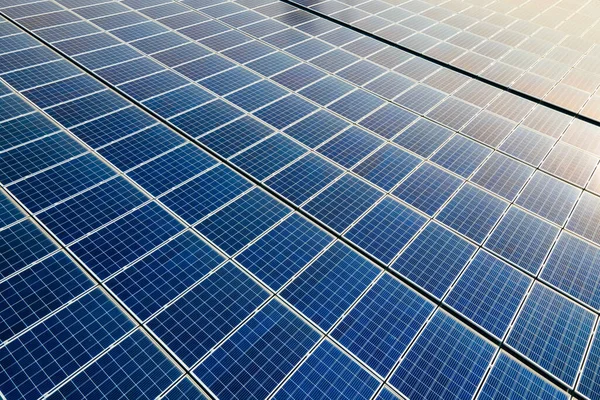 Fechar a superfície dos painéis solares fotovoltaicos azuis montados no telhado da construção para produzir eletricidade ecológica limpa. Conceito de produção de energias renováveis — Fotografia de Stock