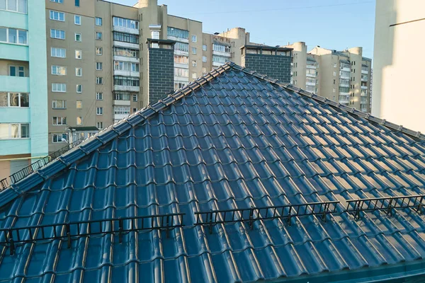 Крупный план снегозащитника для безопасности в зимний период на крыше дома покрыты керамической черепицей. Плиточные покрытия зданий — стоковое фото