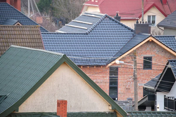 Residential houses with roof tops covered with metallic and ceramic shingles in rural suburban area — Stockfoto