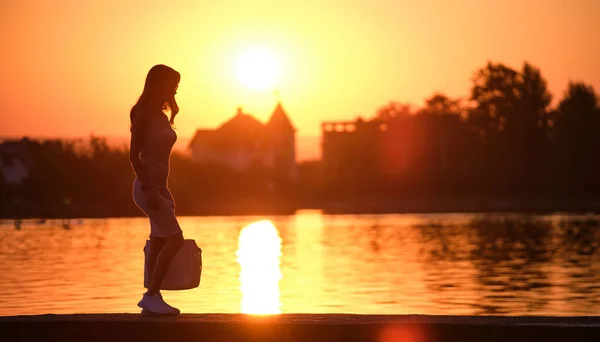 젊은 여자가 따뜻 한 저녁에 혼자 호숫가를 걷고 있다. 자연의 개념 에서의 고독 과 긴장 — 스톡 사진