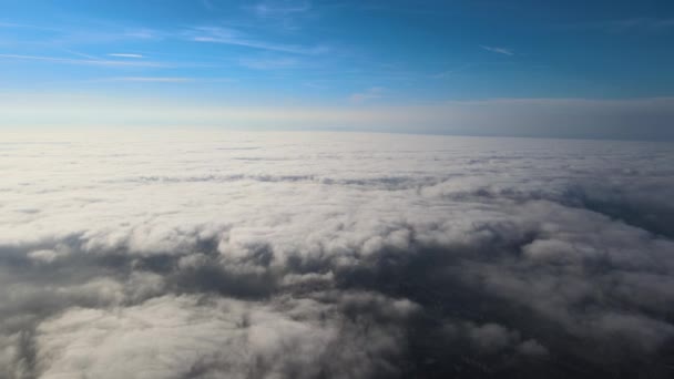 Luftaufnahme aus der Höhe einer weit entfernten Stadt, die vor dem Regensturm mit geschwollenen Kumuluswolken bedeckt war. Blick aus dem Flugzeug auf bewölkte Landschaft — Stockvideo