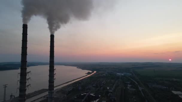 Vista aérea de las tuberías altas de la central eléctrica de carbón con humo negro que se mueve hacia arriba contaminando la atmósfera al atardecer. Producción de energía eléctrica con concepto de combustibles fósiles — Vídeos de Stock