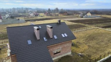 Seramik kiremitlerle kaplı evin çatısının havadan görünüşü. İnşaat halindeki binanın döşemeleri