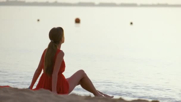 Jeune femme heureuse en robe rouge se détendre sur la plage de sable fin au bord de la mer profitant matin tropical chaud — Video